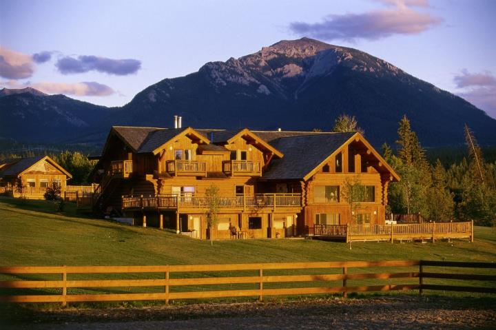 Front of wooden building bathed in sunlight with mountain backdrop