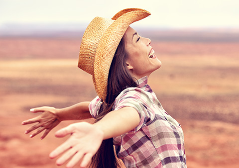 A cowgirl holding her arms stretched out
